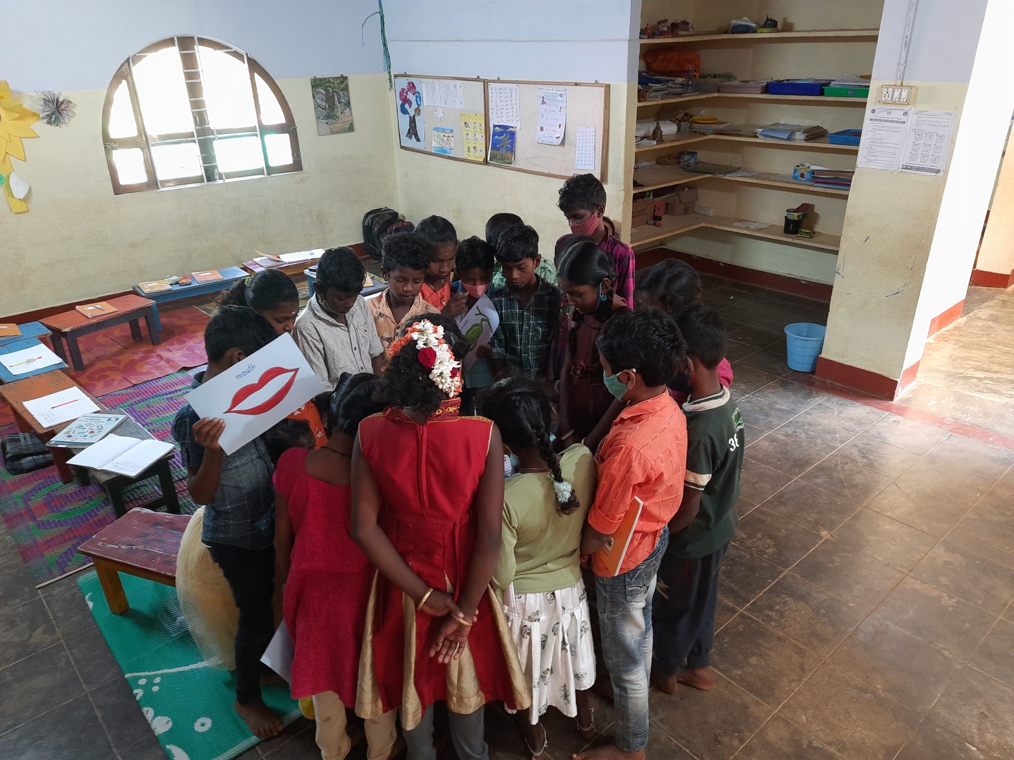 Children clustered together in a reading and learning circle inside a library room