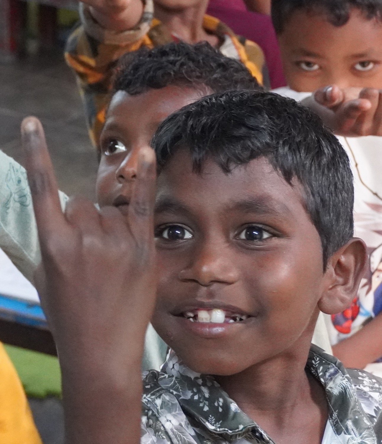 A grinning Adivasi boy with classmates behind him