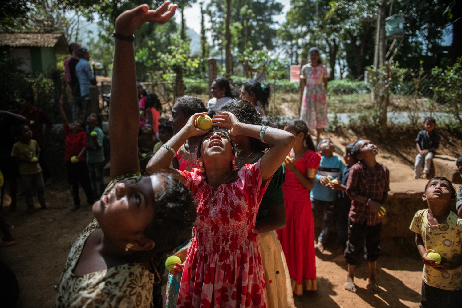 Children at play with balls during an outdoor camp, the Nilgiri hills behind