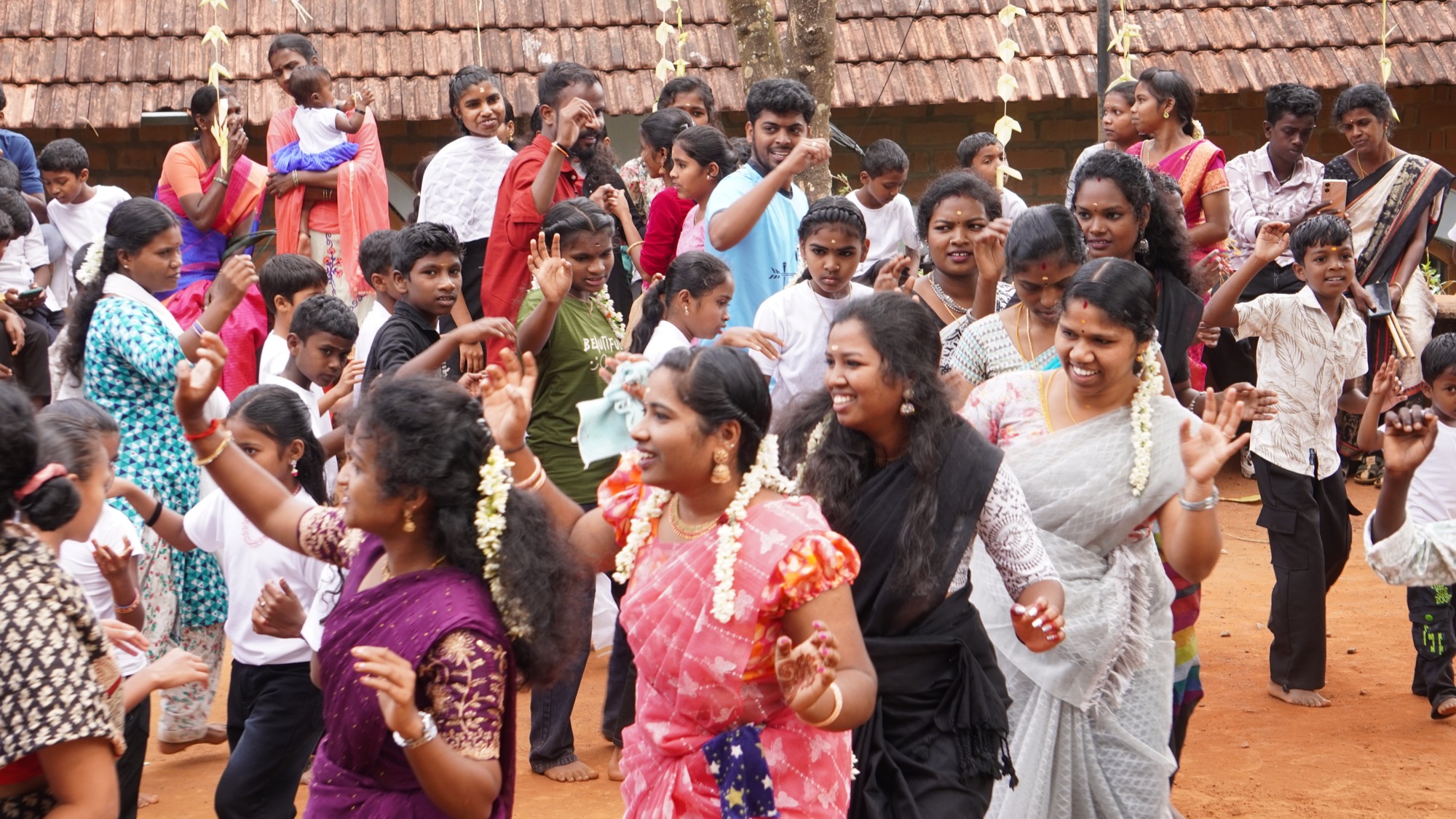 Large joyful crowd of women and children dancing together at the Adivasi day festival
