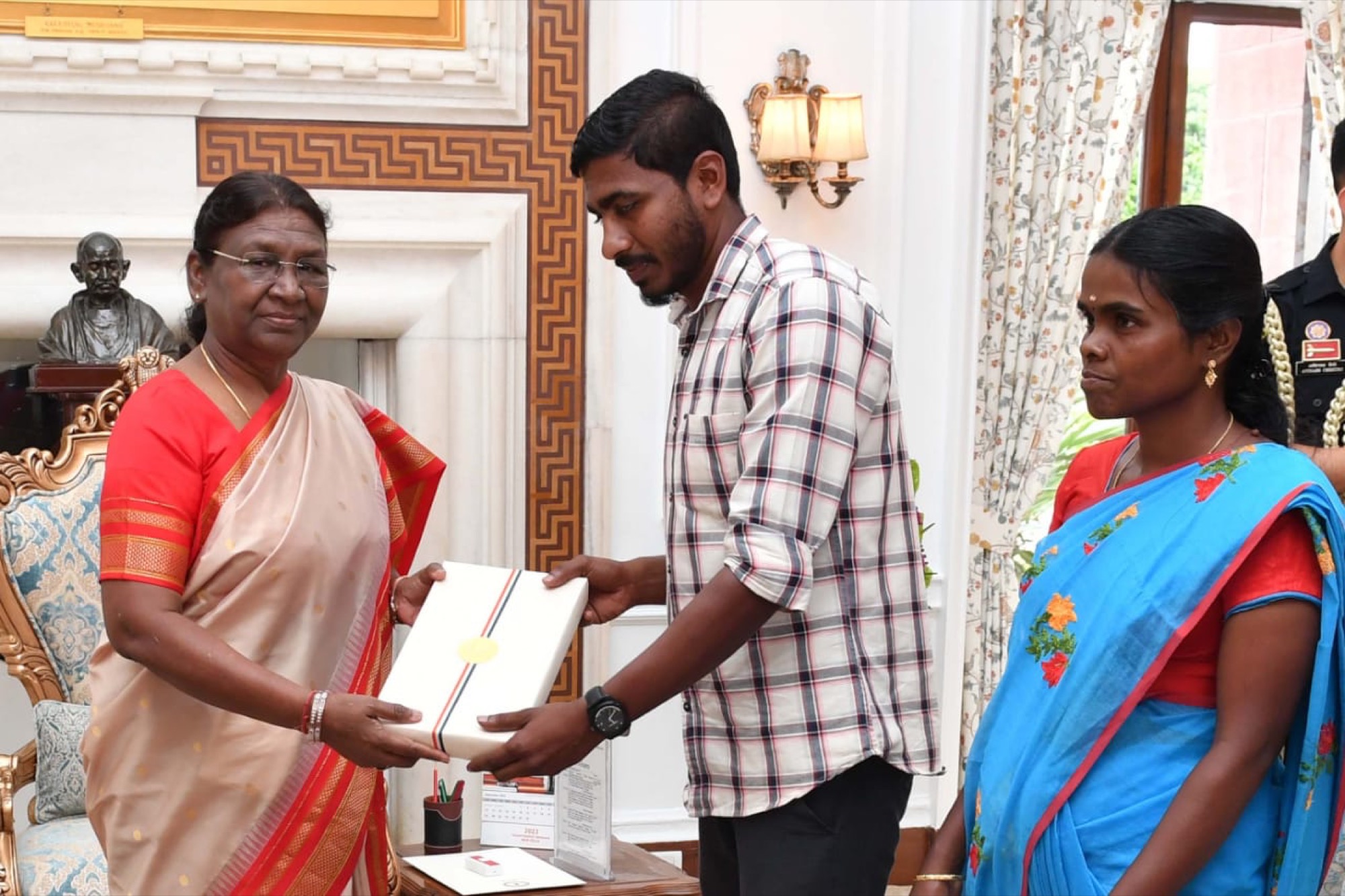 Young Adivasi man and woman honoured by India's President Droupadi Murmu at a formal ceremony