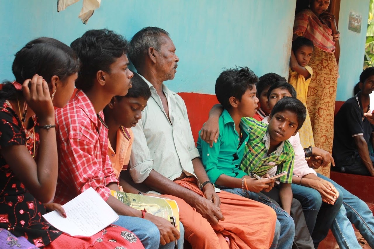 Children and families gathered together at a village meeting